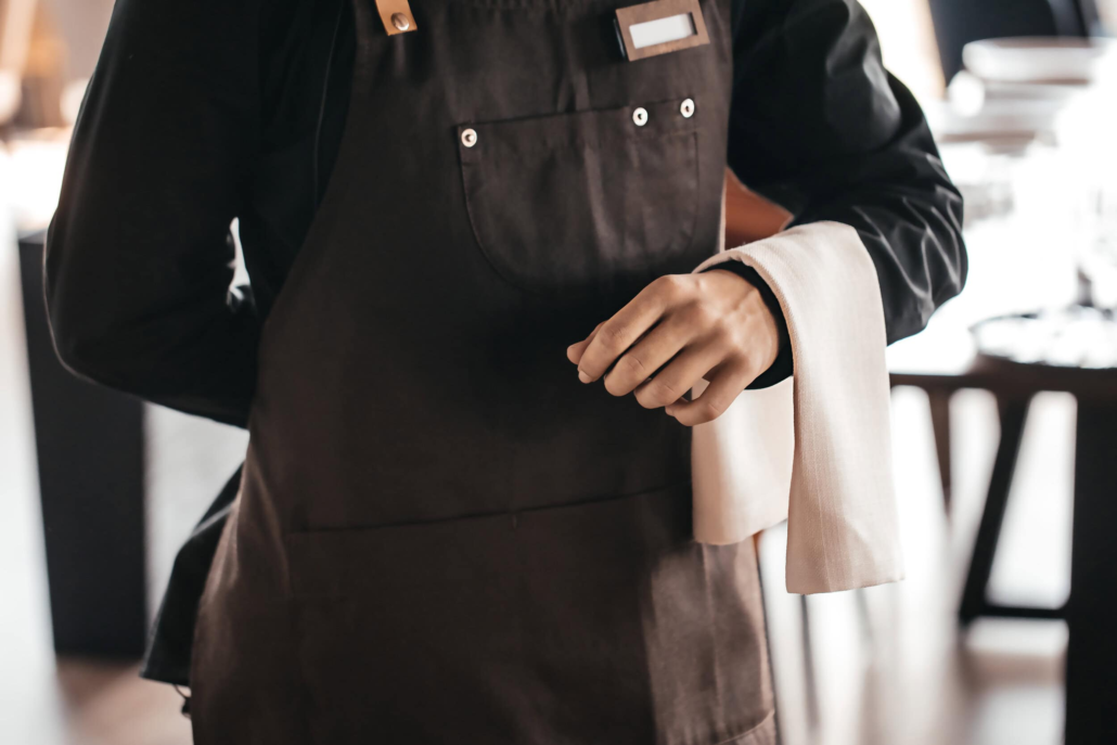 professional-waiter-in-a-dark-apron-holding-a-whit-2026-09-25-07-26-03-utc-1.webp
